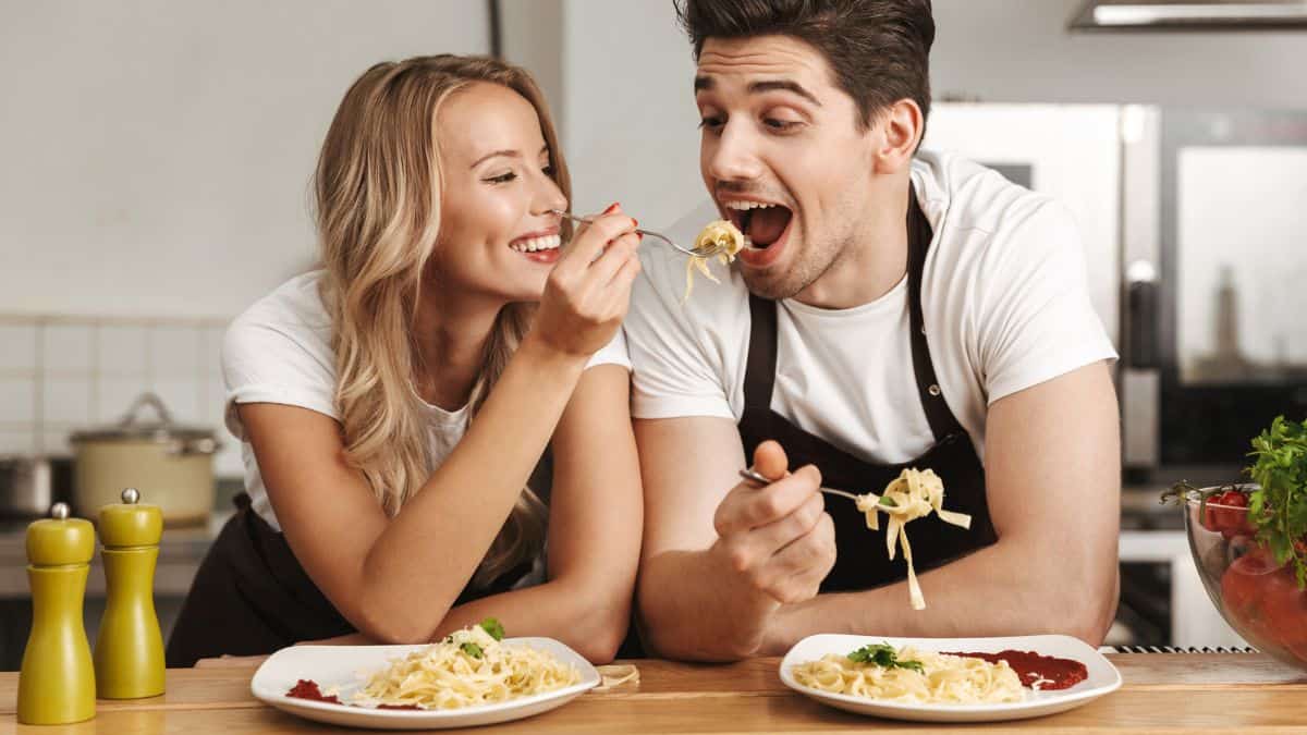 Happy Couple Woman Feeding The Man With Pasta Food