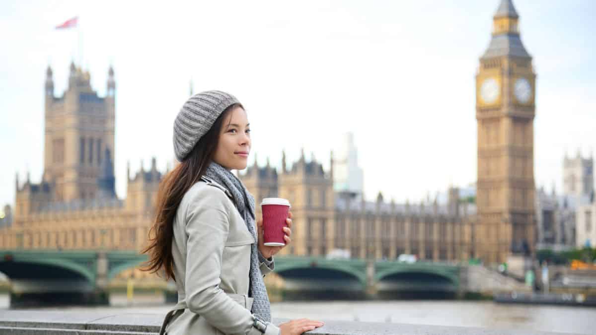 Tourist Woman Drinking Coffee By Westminster Bridge In London