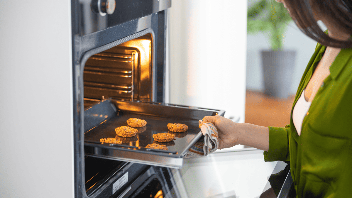Woman Opening The Oven Stock