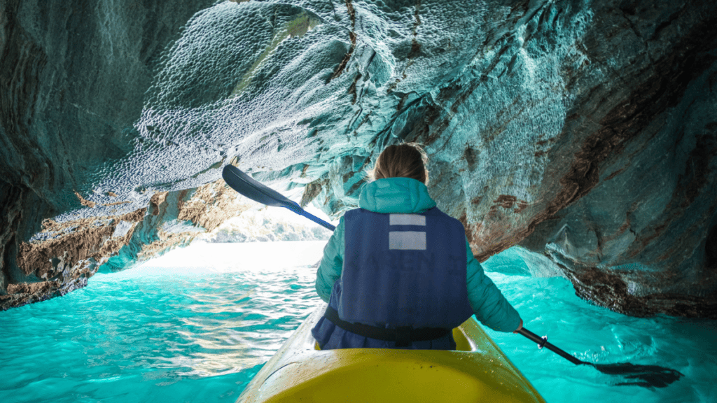 Woman paddles kayak and explores the Marble Caves Stock