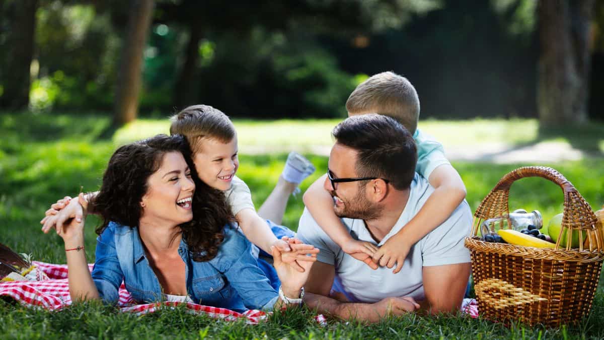 Happy family enjoying picnic with kids in nature Stock