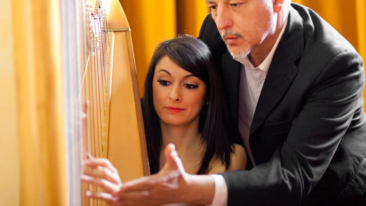 Woman learning to play the harp Stock