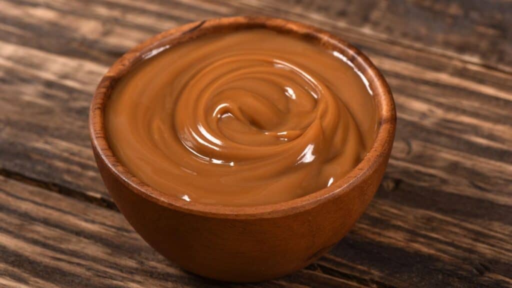 Dulce de leche on wooden bowl Stock