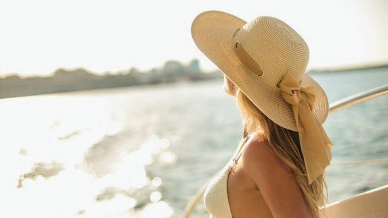 Beautiful woman in bikini and hat enjoying vacation stock