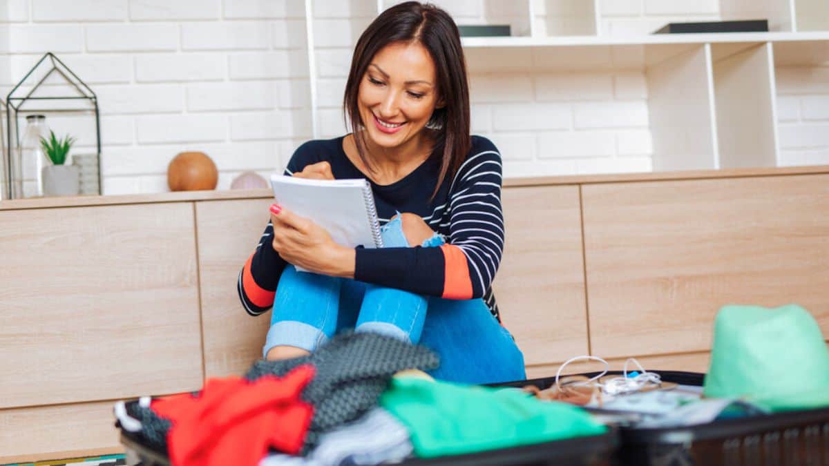 Beautiful young woman packing her stuff Stock