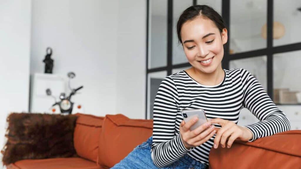 Woman Looking At Phone Smiling Stock