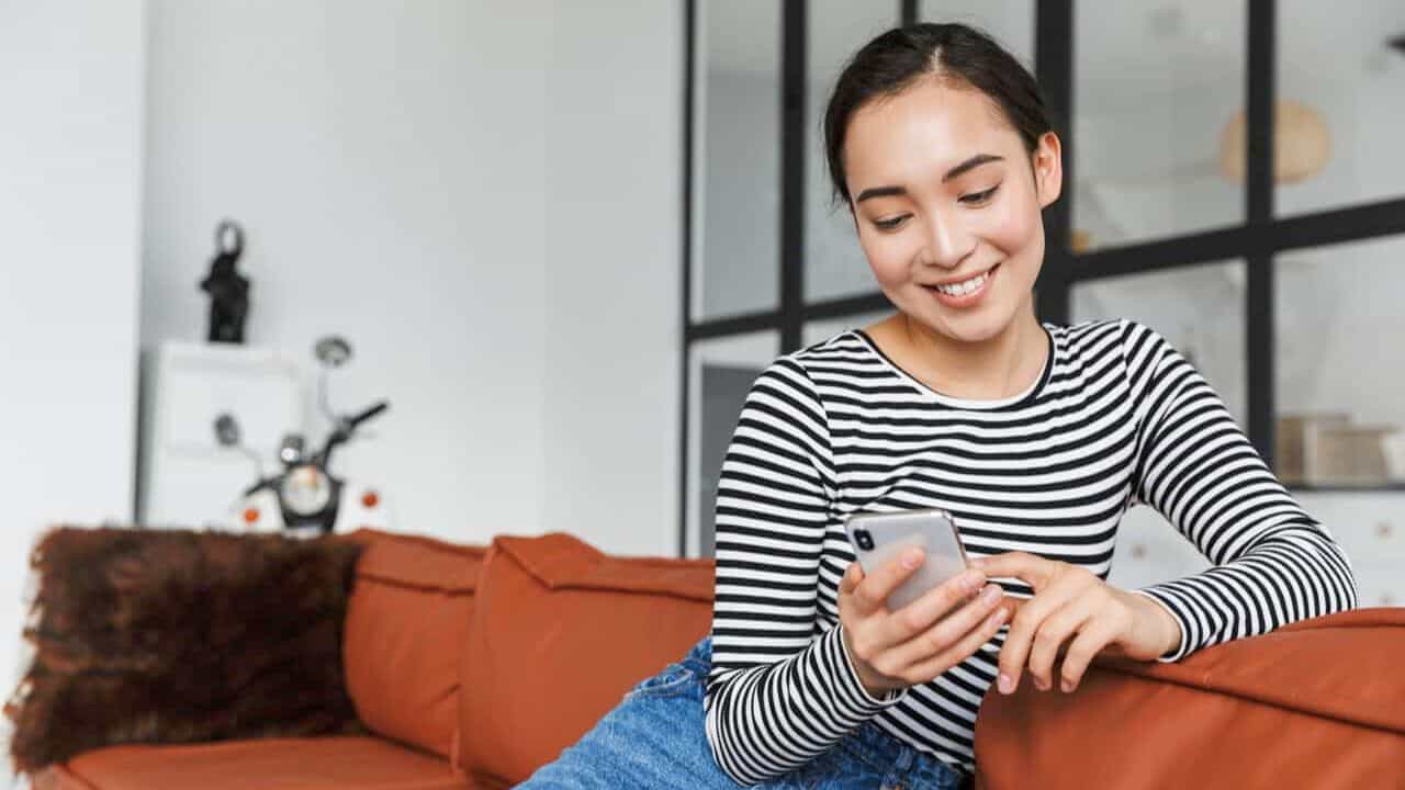 Woman Looking At Phone Smiling Stock