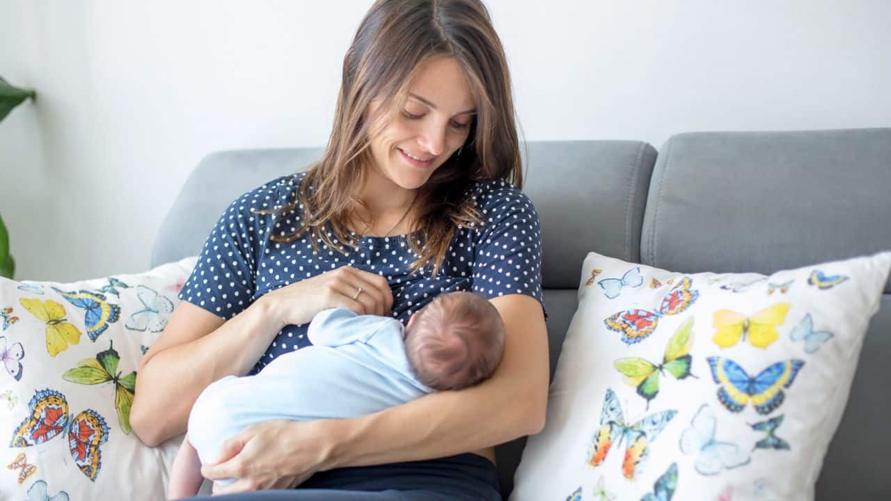 Young mother breastfeeding her baby stock