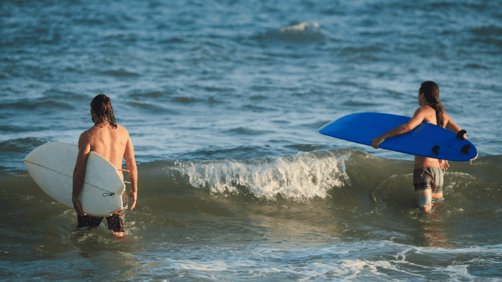 Surfers Walking to Catch Waves Stock