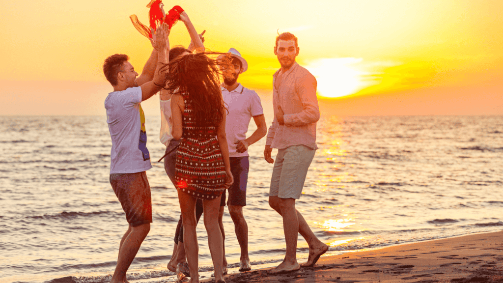 Young People Damcing on Beach Stock