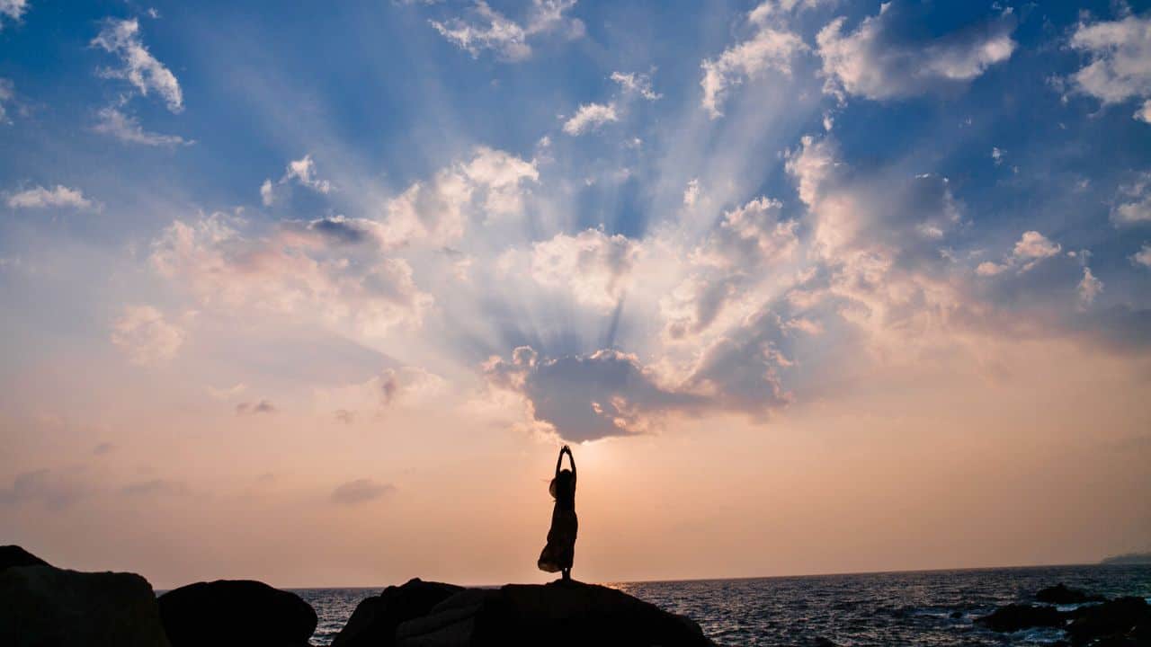 Young beautiful woman posing on beach at sunset Stock