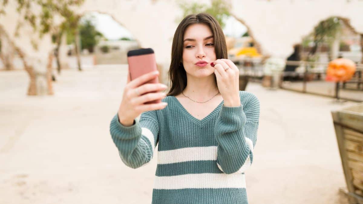 Woman Filming Herself with Phone Outside Using Lipstick MSN